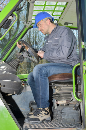 male operator driving excavator on construction building site