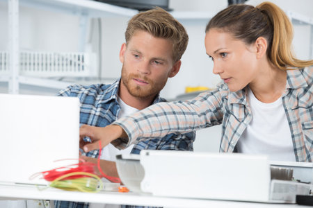 man fixing computer with woman watching