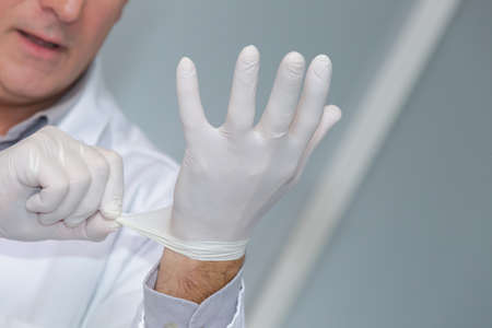 doctor putting on protective glovesの写真素材
