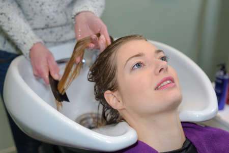 client is resting while her hair is being cleansedの写真素材