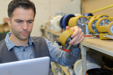 man checking small wheel stock in computer