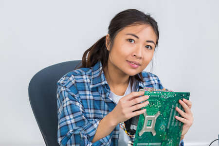 female technician soldering mother board of computorの写真素材
