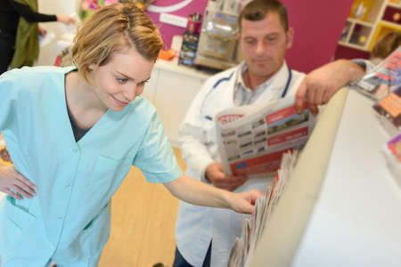 pharmacist checking medicine in shelf at pharmacyの写真素材