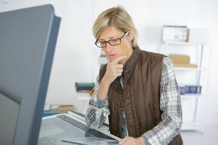 mature female technician searching cause of machine failure