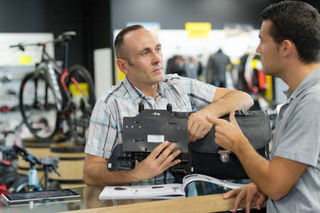 man asking seller for help in sport bike shopの写真素材