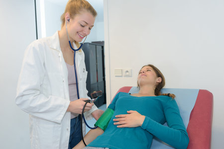 nurse checking blood pressure of a pregnant woman