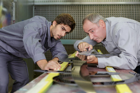 worker cuts metal sheet with a cutterの写真素材