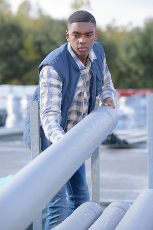 strong construction worker rolling a concrete pipeの写真素材