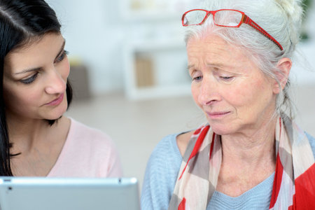 nurse is helping old woman managing her daily tasks