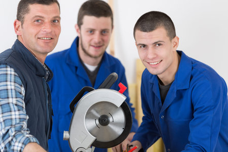 professional teacher showing carpentry machinery to students