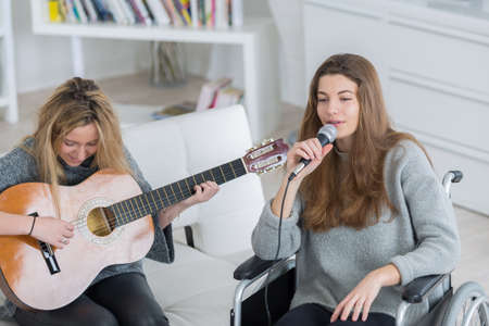 girl teaching her friend to play guitarの写真素材