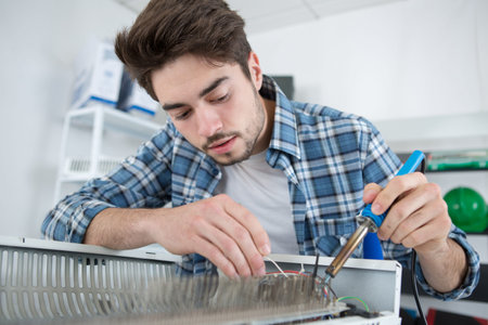 man fixing radiator soldering parts