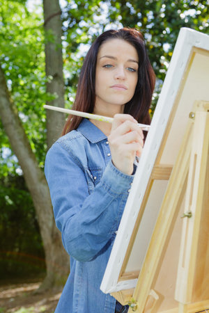 young lovely caucasian woman painting outdoorsの写真素材