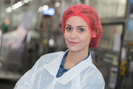 joyful female worker in white uniformの写真素材