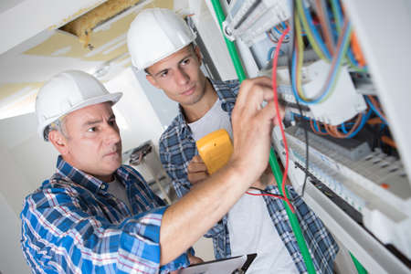 tutor instructing trainee electricianの写真素材