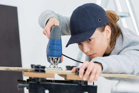 female carpenter using bandsawの写真素材