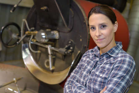 portrait of diligent smiling female posing in factoryの写真素材