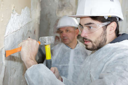 worker scraping the wallの写真素材