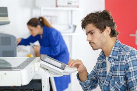 man using control pad on printer