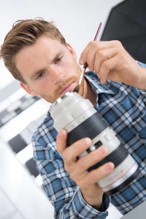 man cleaning camera lenseの写真素材
