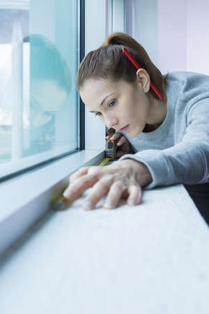 Woman measuring the window areaの写真素材