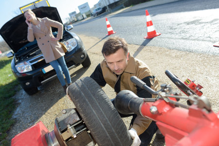 young woman and mechanic assistance on roadside with car breakdown