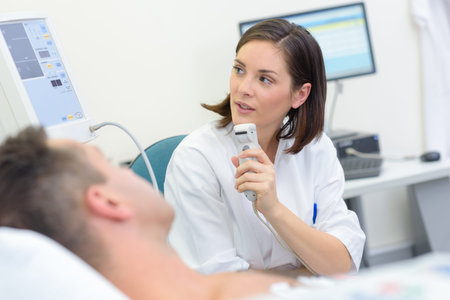nurse adjusting bed with remote control for patient at hospital