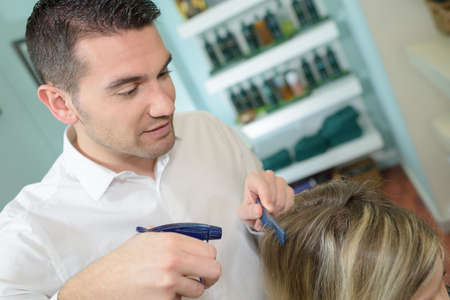 male hairdresser with customer in a hairdressing salonの写真素材