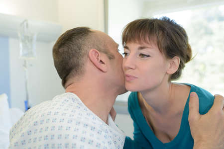 girlfriend kissing sick man giving him love and supportの写真素材