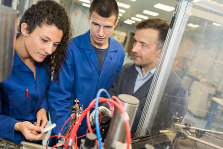 metalworker with training people using electronic machineの写真素材