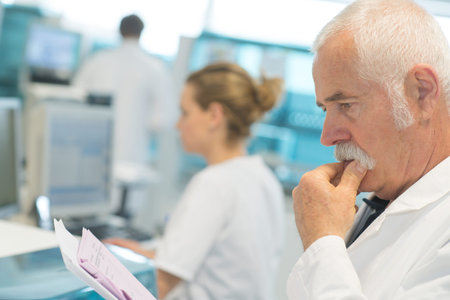 male medicine doctor reading document on clipboard