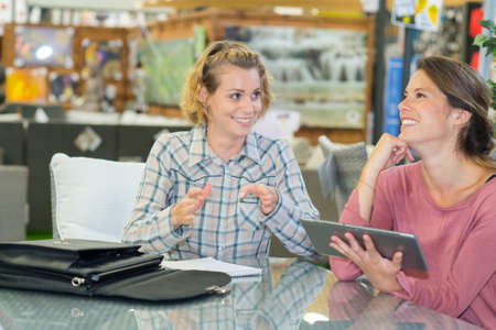 happy salesman assisting customer in choosing pet foodの写真素材