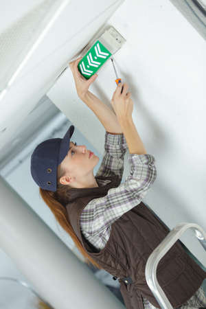 woman putting exit sign on a doorの写真素材