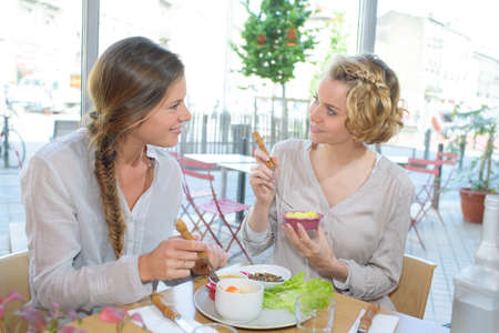 female friends having lunch together at a restaurantの写真素材