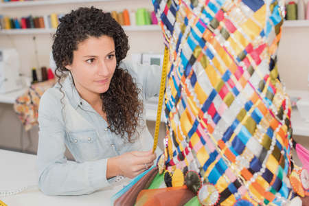 woman dressing a tailor dummy mannequinの写真素材