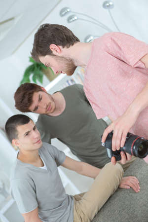 Handsome casual young men check an image on his cameraの写真素材