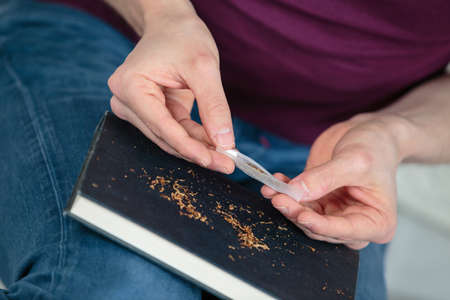 hands of a person rolling a cigarの写真素材
