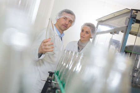 workers and water bottles on production lineの写真素材