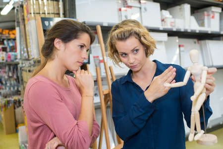 young brunette woman buying drawing model in art departmentの写真素材