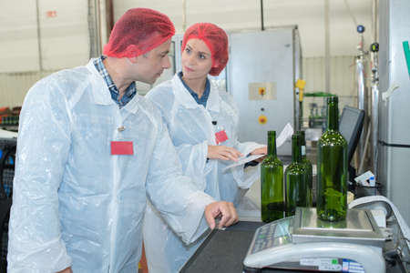 quality control of bottles against bright lightの写真素材