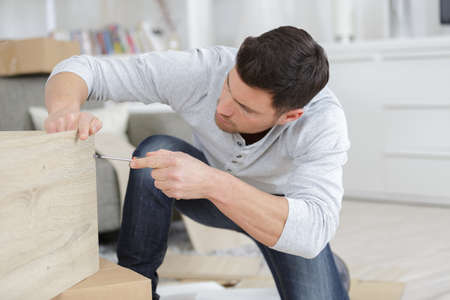 man assembling the delivered furnitureの写真素材