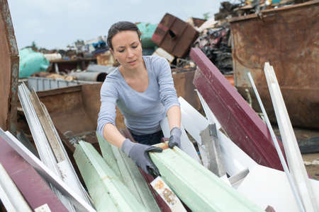 A woman landfill employee working in a skipの写真素材