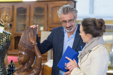 handsome seller and pretty woman buying scultpureの写真素材