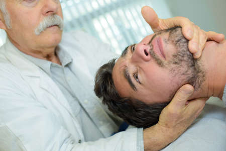 A physical therapist giving neck massageの写真素材