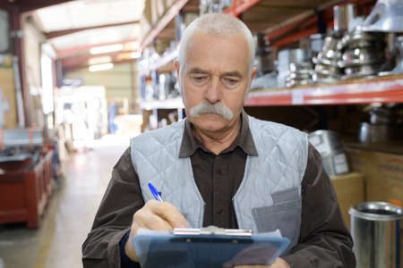 senior stock keeper working in warehouseの写真素材