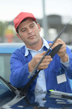 man is changing windscreen wipers on a carの写真素材