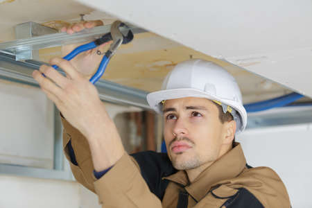 man putting up a suspended ceilingの写真素材