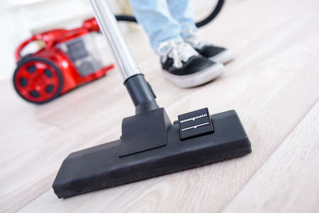 woman using vacuum cleaner in the living roomの写真素材
