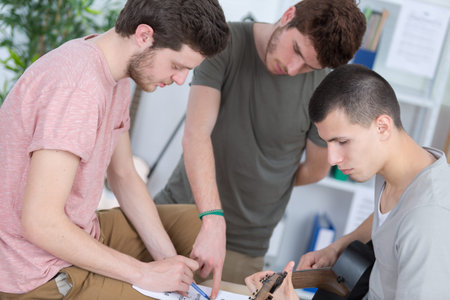 teen guys composing music at home