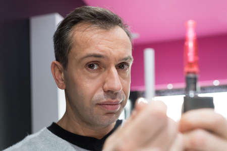man trying to smoke an electronical cigaretteの写真素材